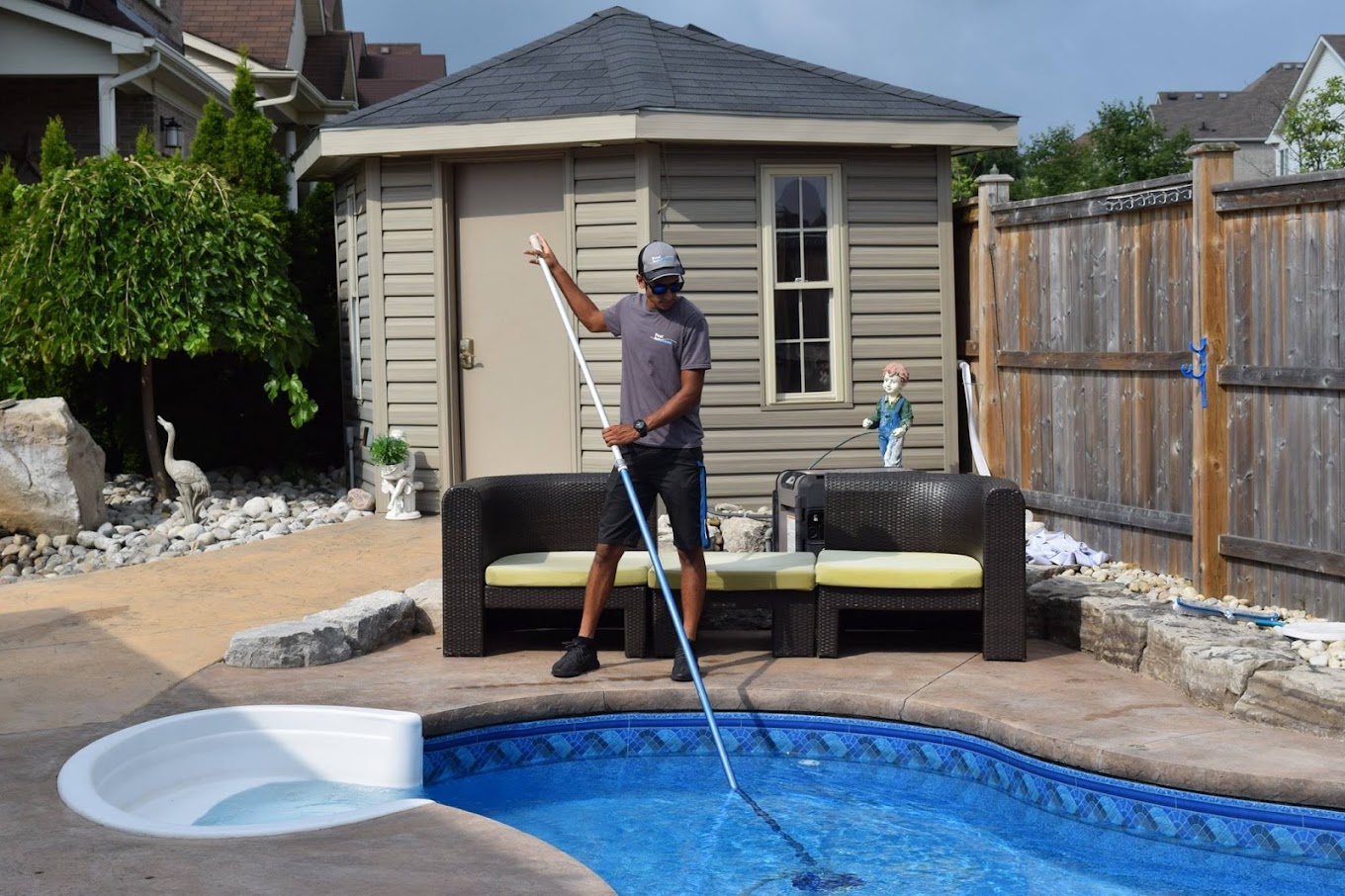 Technician cleaning a pool in Waterloo as part of professional pool maintenance services.